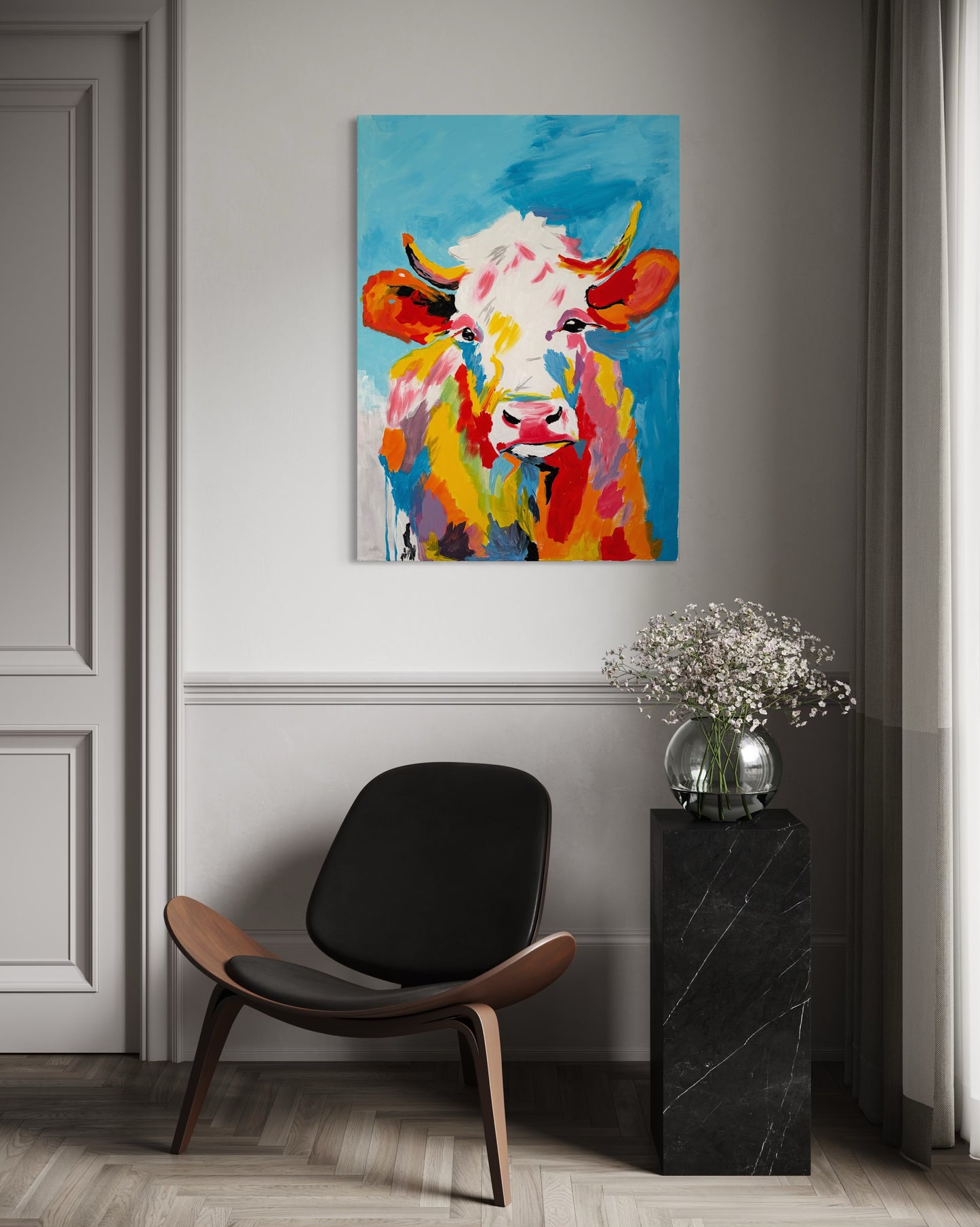 Colorful abstract cow painting by J.Cortes on a wall above a modern chair.