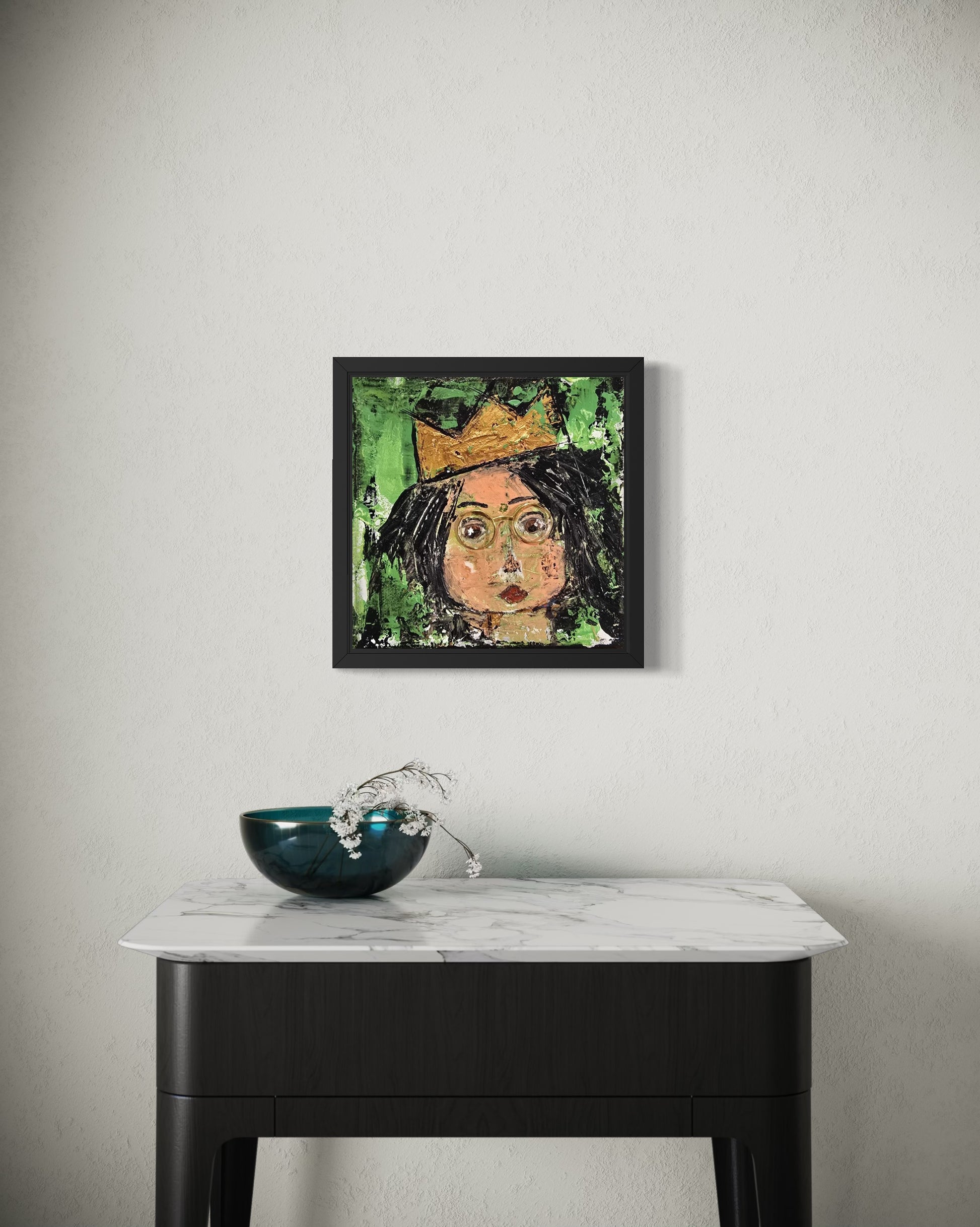 Dalla myndlist, Untitled. Framed artwork of a person with a crown on a wall above a marble table with a decorative bowl.