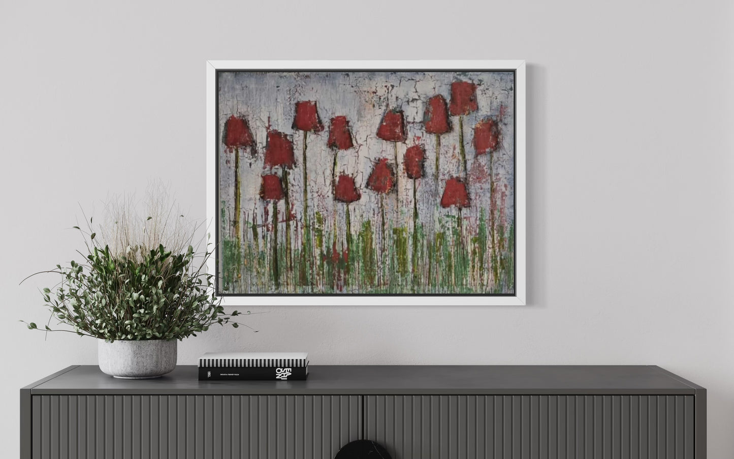 Dalla, Untitled. Framed artwork of red tulips on a gray wall above a console table with a plant.